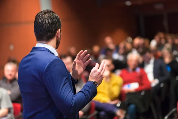 Public speaker giving talk at Business Event.