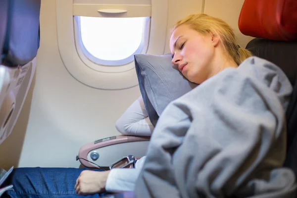 Lady traveling napping on a plain.