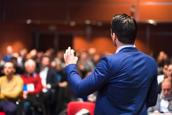 Public speaker giving talk at Business Event.