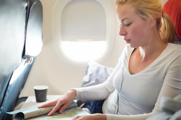 Woman reading magazine on airplane.