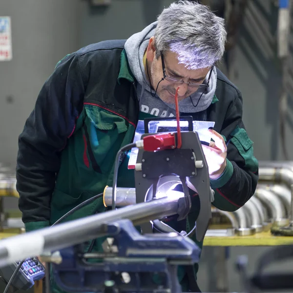 Industrial worker setting orbital welding machine.