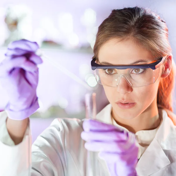 Young scientist pipetting in life science laboratory.