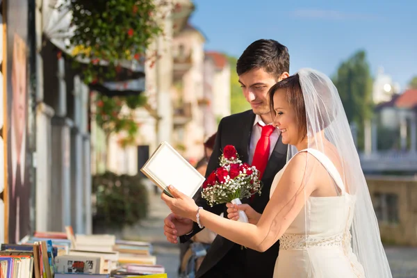 Beautiful wedding couple reviewing vintage books.