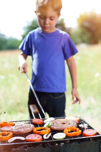 Boy grilling vegetable.