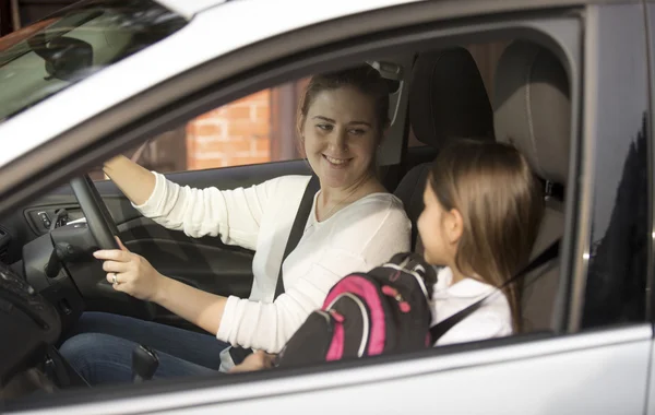 Portrait of mother driving her daughter to school at morning