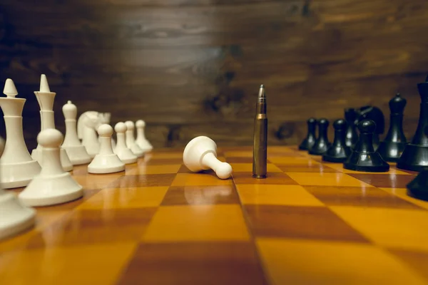 Closeup of bullet winning in chess game. Concept of power of gun