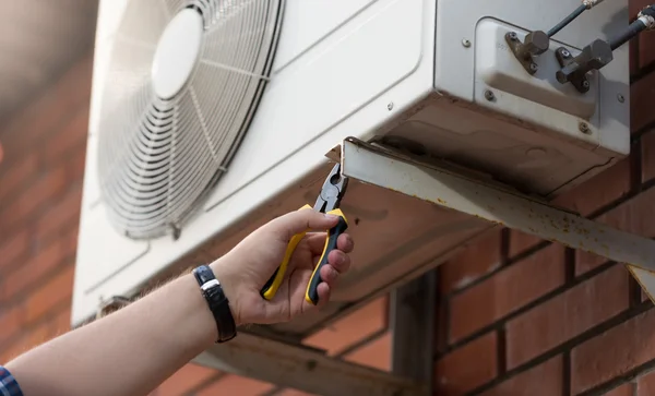 Closeup photo of technician installing outdoor air conditioning