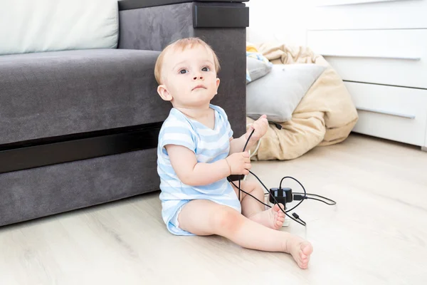 Concept of baby in danger. Baby boy sitting on floor alone and p