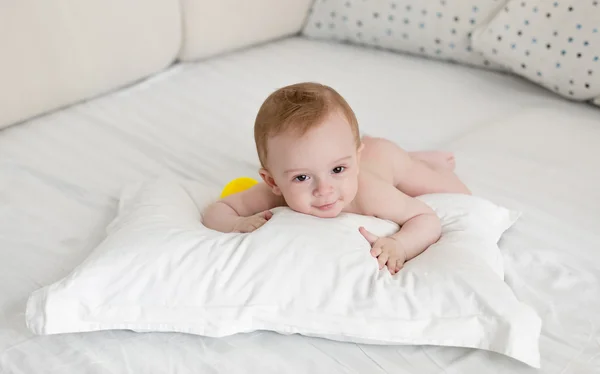 Adorable baby boy relaxing on pillow after bathing