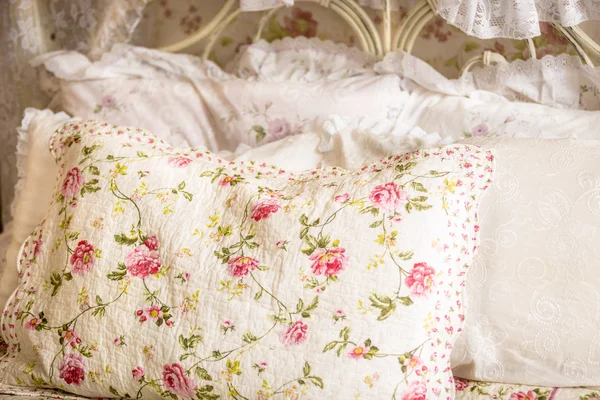 Photo of pillow with floral print on big bed