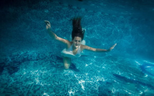 在游泳池里游泳的长头发的女人 - 图库照片Kry