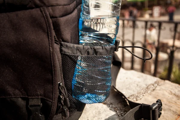 Plastic bottle of water in black backpack