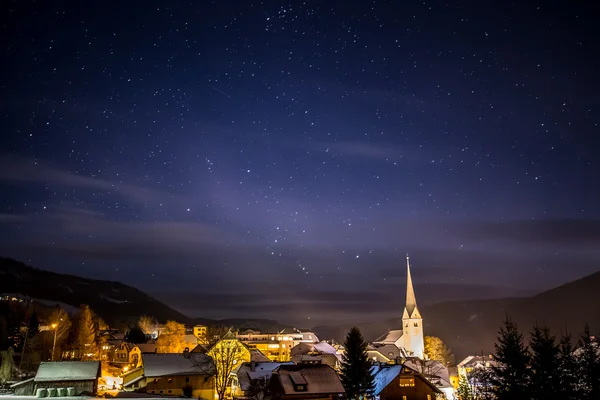 Clean night starry sky over highland Austrian town