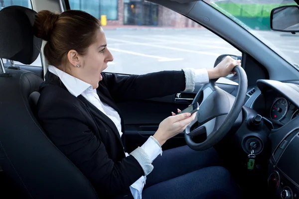 Distracted woman using smartphone and driving a car