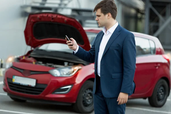 Businessman searching in mobile phone how to repair car