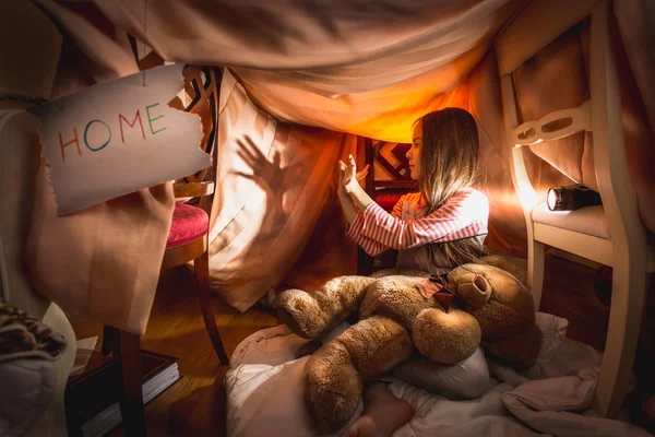 Girl made theater of shadows in self-made house at bedroom