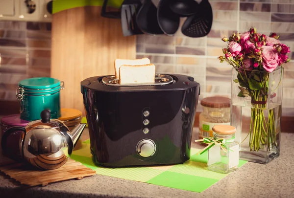 Toned shot of toaster with fresh brad on decorated kitchen