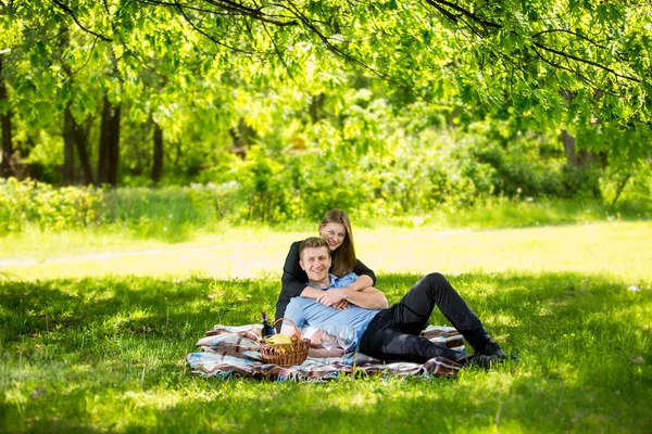 Beautiful couple in love relaxing under tree at park
