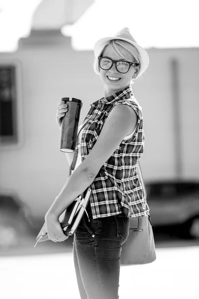Black and white portrait of smiling stylish girl on street