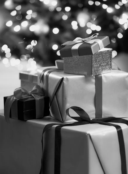 Black and white photo of Christmas gift boxes lying on floor