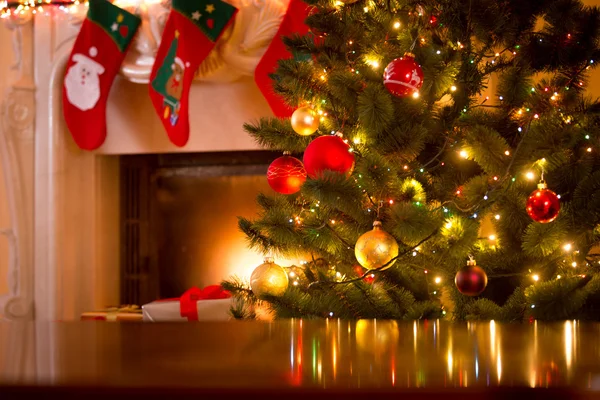 Christmas background of table against Christmas tree and firepla