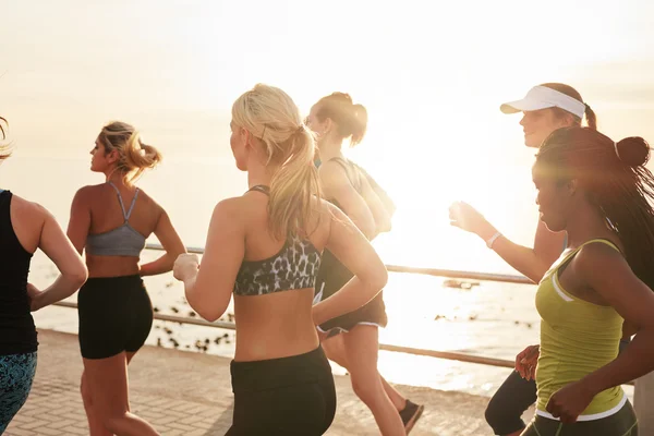 Group of fit young women running together