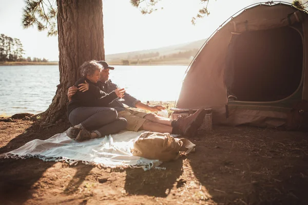 Loving senior couple camping near a lake