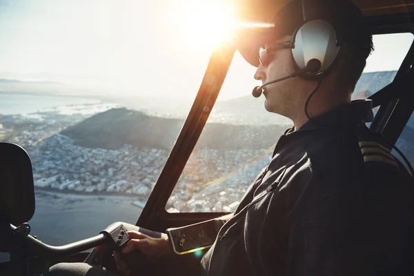 Male helicopter pilot flying aircraft