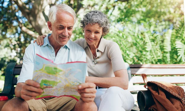 Happy mature couple using city map for direction