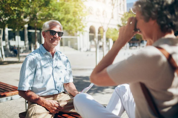 Senior man being photographed by his wife