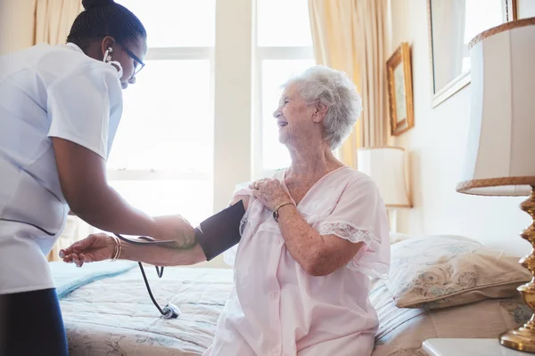 Nurse checking blood pressure of a woman