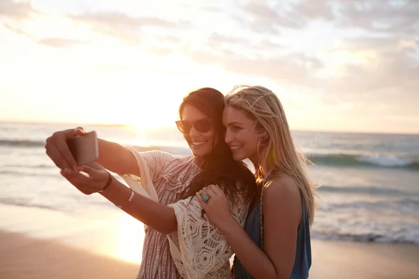 Happy women taking selfie on the beach