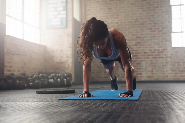 Muscular woman doing core exercise