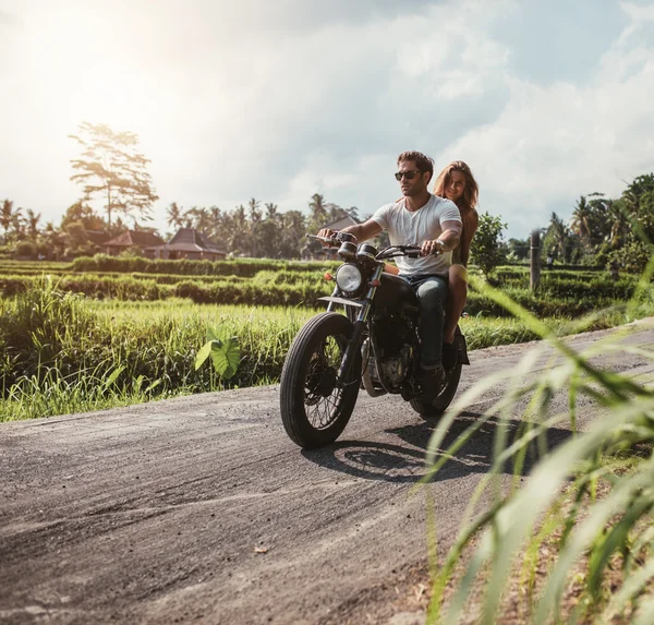 Couple riding motorcycle on country road