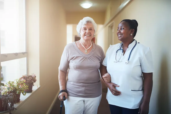 Happy doctor and patient together at nursing home