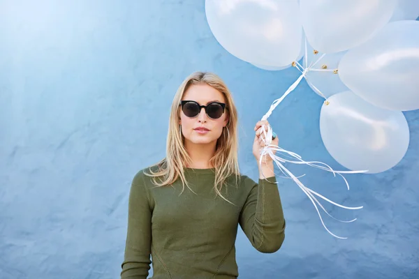 Stylish young woman with white balloons