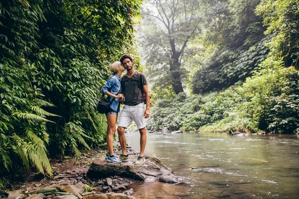 Loving couple standing by mountain stream