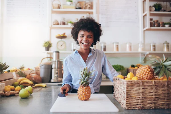 Cheerful young african woman working at juice bar