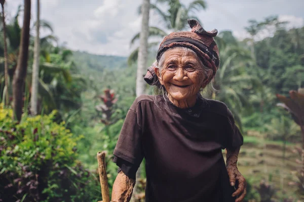 Happy senior woman with a cane in village