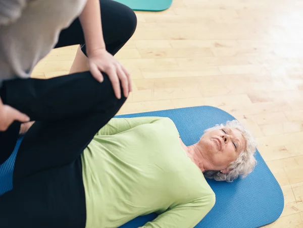 Elder woman receiving physical training from her personal traine