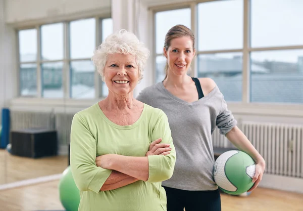 Senior woman at health club with gym instructor