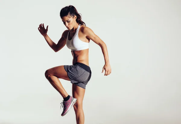 Attractive fit woman exercising in studio with copyspace