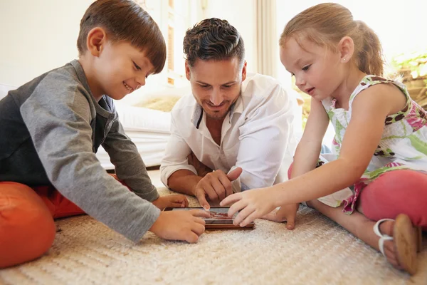 Father and children spending time together using digital tablet