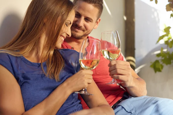 Smiling young couple celebrating with wine