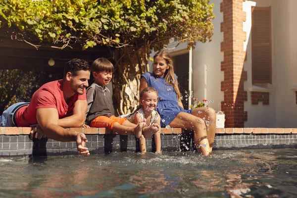 Happy family having fun by the swimming pool