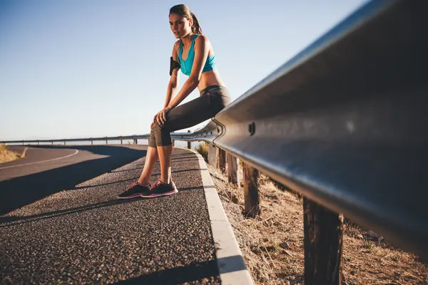 Young female runner taking a break