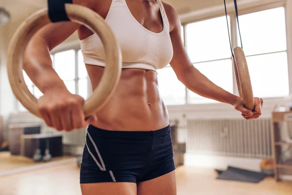 Woman's hands holding gymnastic rings