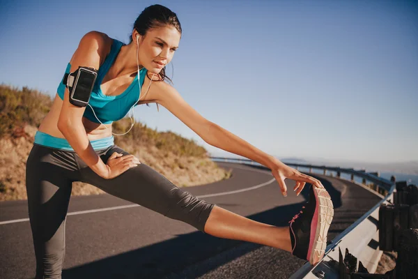 Determined young woman warming up before a run