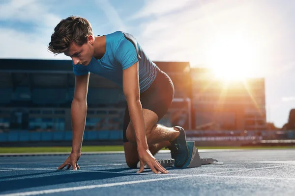 Athlete at starting block on running track