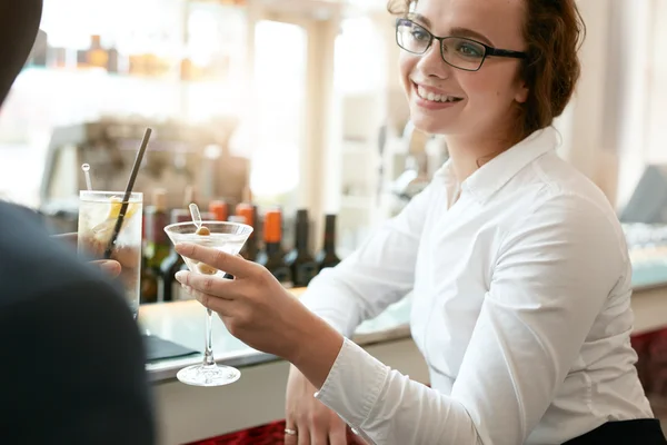 Businesswoman toasting drink with colleague at cafe